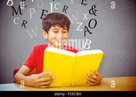 Zusammengesetztes Bild des netten jungen Lesebuch in Bibliothek Stockfoto