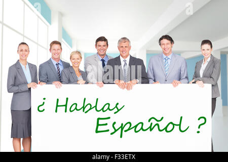 Zusammengesetztes Bild des Lächelns Business-Team hält Plakat Stockfoto
