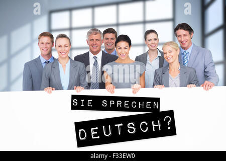 Zusammengesetztes Bild des Lächelns Business-Team hält Plakat Stockfoto