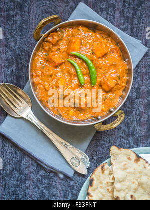 Paneer Tikka Masala (indische Küche) in einer traditionellen Kupfer Schüssel mit tandoori Roti serviert. Draufsicht. Stockfoto