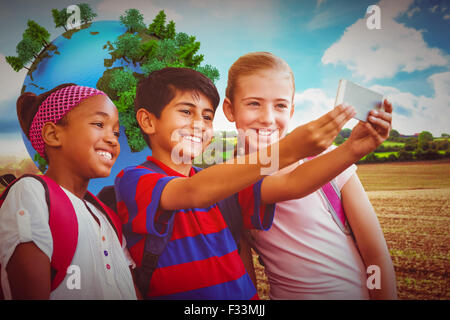 Zusammengesetztes Bild der glückliche Kinder nehmen Selfie im Flur der Schule Stockfoto