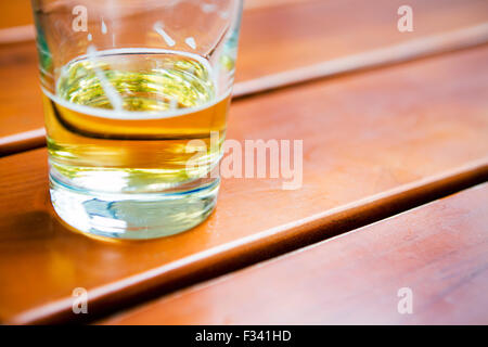 halb leeren Glas Bier auf Holztisch Stockfoto