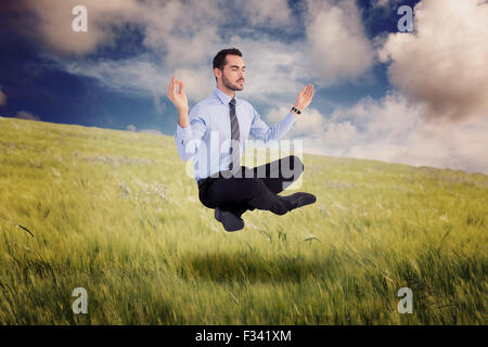 Zusammengesetztes Bild entspannt Geschäftsmann in Lotus Pose sitzen Stockfoto