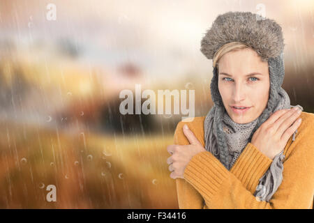 Zusammengesetztes Bild der Frau in Winterkleidung zitternd auf weißem Hintergrund Stockfoto