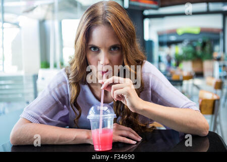 Hübsche Brünette nippen an einem smoothie Stockfoto