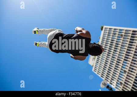 Sportlicher Mann tun Back Flip in der Stadt Stockfoto