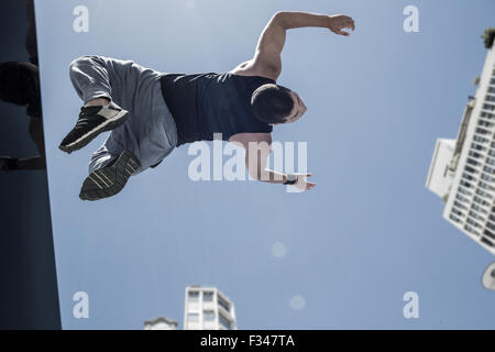 Sportlicher Mann tun Back Flip in der Stadt Stockfoto