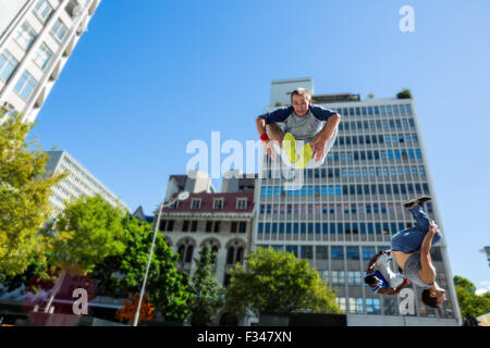 Glückliche Freunde tun Parkour in der Stadt Stockfoto