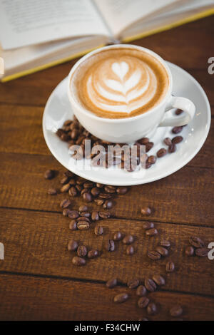 Tasse Cappuccino mit Kunst Kaffee und Kaffeebohnen Stockfoto