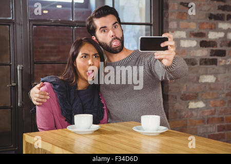 Grimassierende Freunde unter selfies Stockfoto