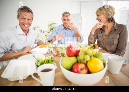 Lächelnde Kollegen dem gemeinsamen Mittagessen Stockfoto