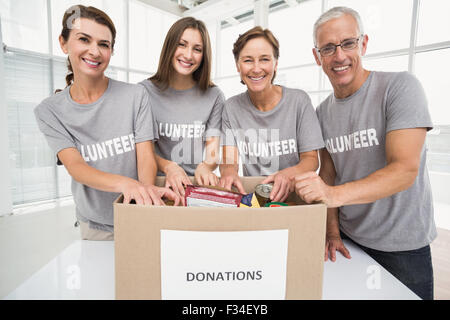 Lächelnde Freiwilligen Sortierung Spendenbox Stockfoto