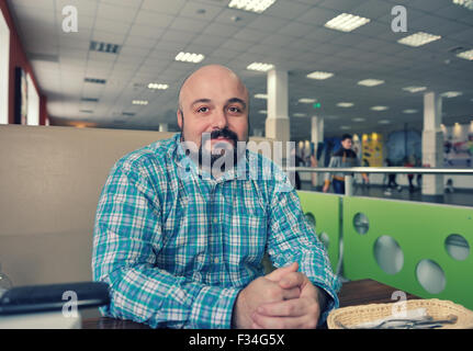 Ein bärtiger Mann in ein kariertes Hemd in der Tabelle-bar Stockfoto