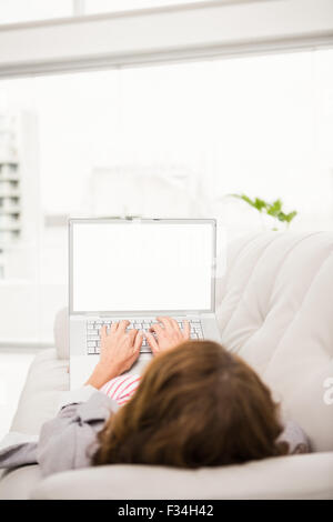 Entspannen Sie sich auf der Couch mit Laptop lässig Geschäftsfrau Stockfoto