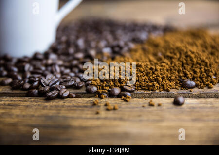 Kaffeebohnen auf einem Tisch mit Tasse Stockfoto
