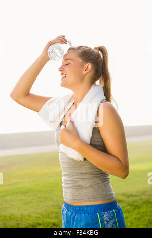 Sportliche Blondine Kühlung Stirn mit Wasserflasche Stockfoto