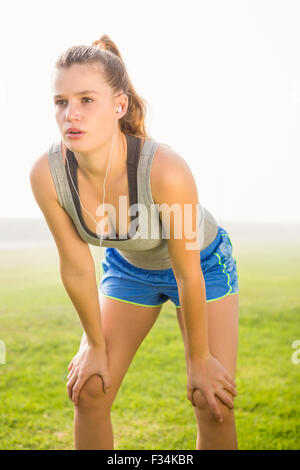 Sportliche Blondine ruht und Musik hören zu atmen Stockfoto