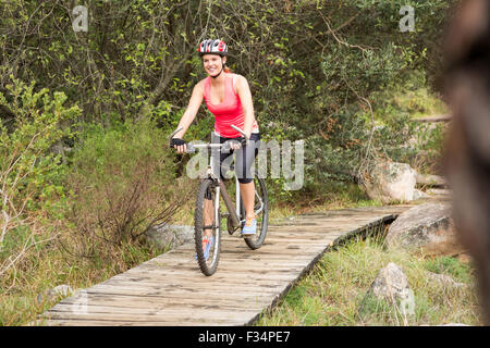 Lächelnde blonde Sportler Mountainbiken Stockfoto
