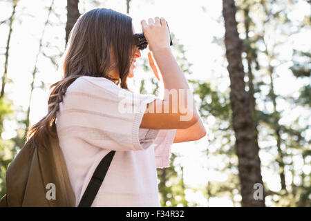 Lächelnde Brünette Wanderer durch ein Fernglas schauen Stockfoto