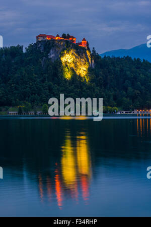 Bled Burg von Bled See in Slowenien beleuchtet auf Wasseroberfläche reflektiert nachts Stockfoto