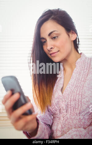 Hübsche Brünette mit ihrem smartphone Stockfoto