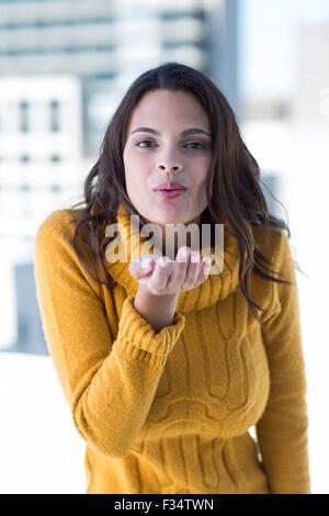 Hübsche Frau bläst Kuss Stockfoto