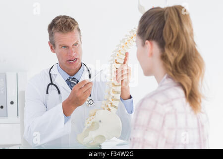 Arzt zeigt seinen Patienten ein Modell der Wirbelsäule Stockfoto