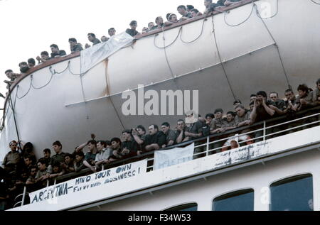 AJAXNETPHOTO. 12TH. MAI 1982 - SOUTHAMPTON, ENGLAND. - TRUPPENSCHIFF - DER CUNARD-LINER QE2 OBERDECKS UND RETTUNGSBOOT ÜBERFÜLLT MIT BRITISCHEN ARMEETRUPPEN, ALS SIE SICH VON DEN WASSERFLÜGLERN UND DER FAMILIE VERABSCHIEDEN, DIE GEKOMMEN WAREN, UM SIE ZU SEHEN UND DAS SCHIFF ZUM SÜDATLANTIK UND DEN FALKLANDINSELN ABFAHREN. FOTO: JONATHAN EASTLAND/AJAX. REF:909601 Stockfoto