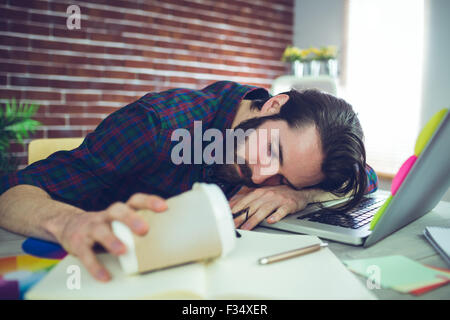Müde Editor Holding Einweg-Becher Stockfoto