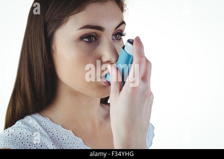 Asthmatische Brünette mit ihrem Inhalator Stockfoto