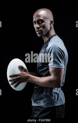 Porträt von zuversichtlich Sportler stehend mit Rugby-ball Stockfoto