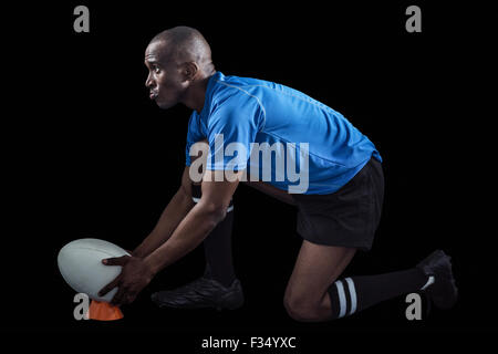 Wegsehen und Ball am Abschlag treten dabei zuversichtlich Rugby-Spieler Stockfoto