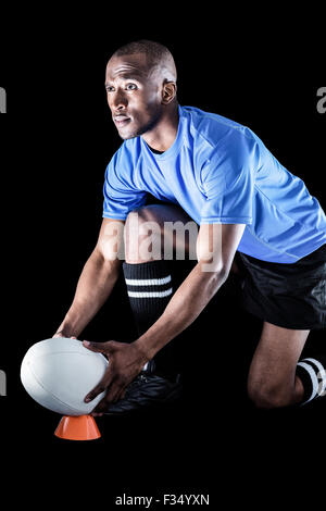 Sportler, die wegsehen und Rugby-Ball am Abschlag treten dabei Stockfoto