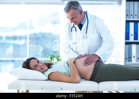 Porträt der schwangeren Frau, die vom Arzt in der Klinik geprüft Stockfoto