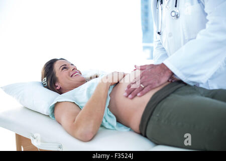 Schwangere Frau, die vom Arzt in der Klinik geprüft Stockfoto