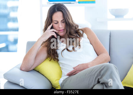 Schwangere Frau sitzen im Wohnzimmer Stockfoto