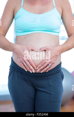 Mittleren Bereich der schwangeren Frau machen Herzform Stockfoto