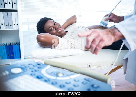 Arzt mit Ultraschall Ergebnissen auf Monitor, Frau Stockfoto