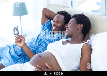 Glückliche Frau betrachten Ultraschalluntersuchung Stockfoto