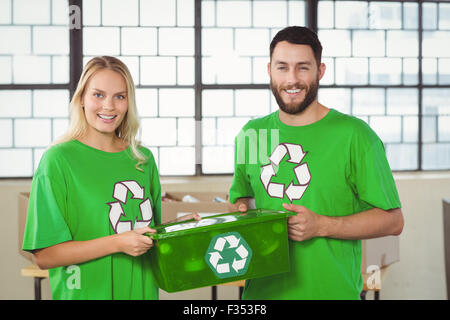 Porträt des Lächelns freiwillige tragen recycling container Stockfoto