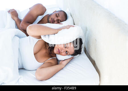 Gestresste Frau schlafen neben Schnarchen Mann Stockfoto