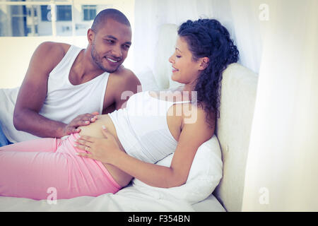 Mann mit schwangere Frau auf Bett liegend Stockfoto