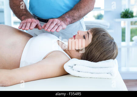 Therapeuten bei Reiki über schwangere Frau Stockfoto