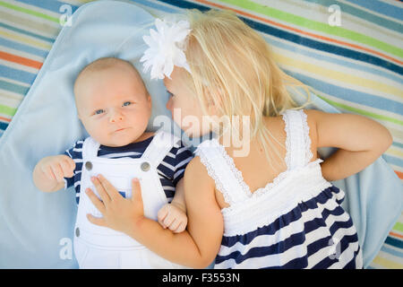 Niedliche kleine Schwester Verlegung als nächstes ihr Baby Bruder auf Decke. Stockfoto