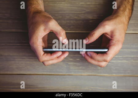 Person, die Mobile Telefon am Schreibtisch Stockfoto