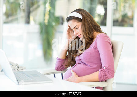 Unglücklich schwangere Frau mit Kopfschmerzen Stockfoto