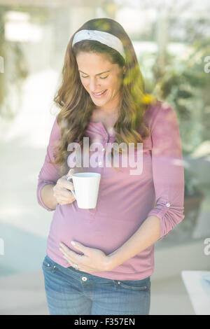 Glückliche Frau mit Kaffeetasse Stockfoto