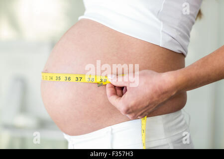 Mittelteil der Frau mit Maßband Stockfoto