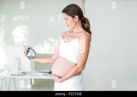 Frau Stirnrunzeln auf Wecker Stockfoto