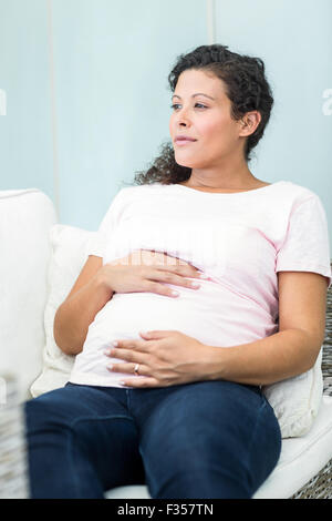 Frau sitzt auf dem Sofa wegschauen Stockfoto